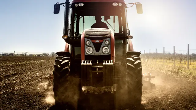 Red tractor working a ploughed field